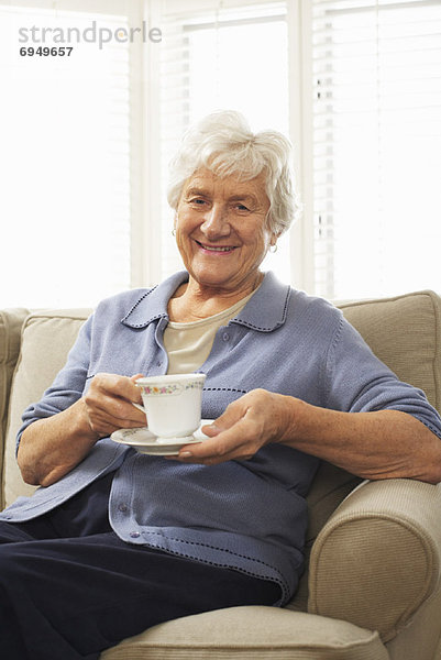 sitzend Senior Senioren Portrait Frau Tasse Couch halten Untertasse