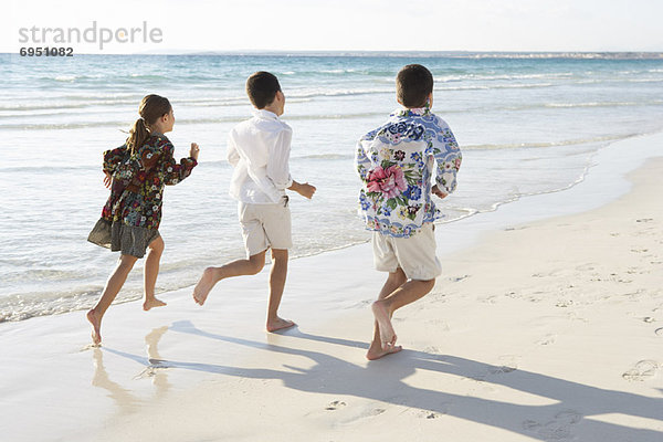 Kinder laufen am Strand