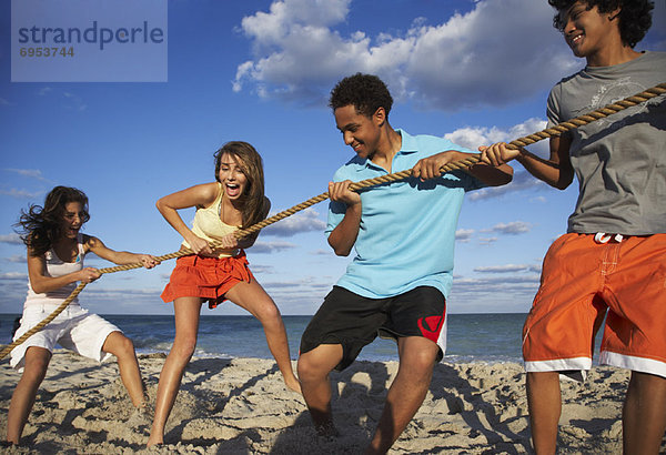 Freundschaft  Strand  spielen  Tauziehen