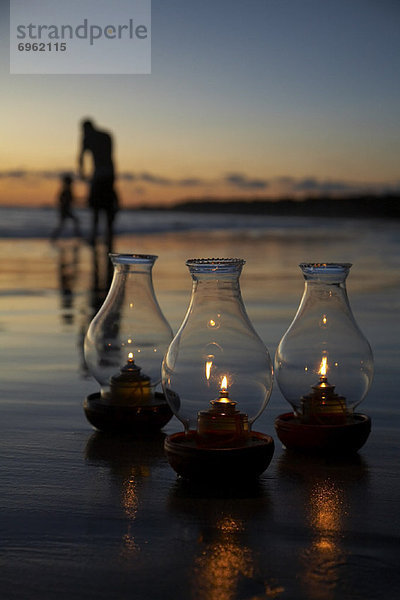 Strand  Sonnenuntergang  Lampe  Menschen im Hintergrund  Hintergrundperson  Hintergrundpersonen  Öl