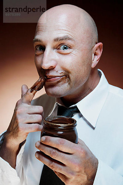 Mann Schokolade essen essend isst Brotaufstrich