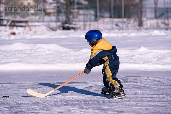 Junge - Person  klein  Österreich  gefroren  Hockey  spielen  Teich  Salzburger Land