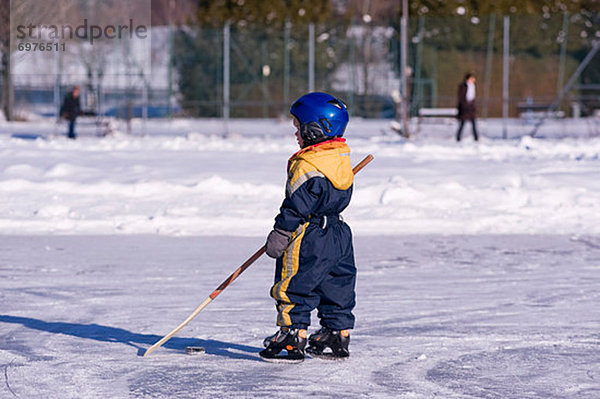 Junge - Person  klein  Österreich  gefroren  Hockey  spielen  Teich  Salzburger Land