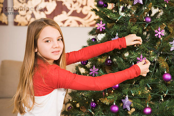 Mädchen dekorieren Weihnachtsbaum