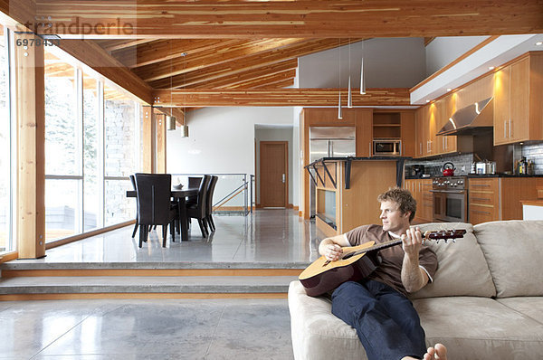 Interior zu Hause Mann Gitarre spielen