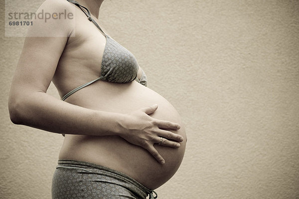 Profile of Woman  Nine Months Pregnant  Touching Her Belly