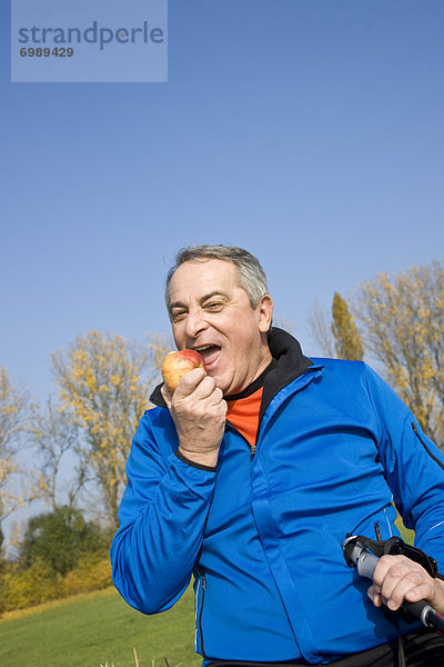 Außenaufnahme  Mann  reifer Erwachsene  reife Erwachsene  Apfel  essen  essend  isst  freie Natur