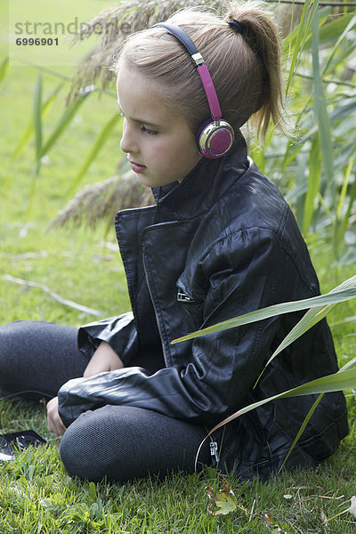 Außenaufnahme  sitzend  zuhören  Musik  jung  Mädchen