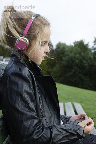 Außenaufnahme  sitzend  zuhören  Musik  jung  Mädchen