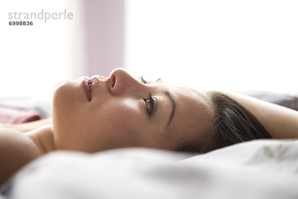 Frau auf dem Bett liegend