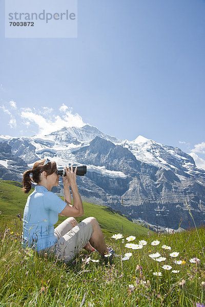 sitzend  benutzen  Frau  Berg  Fernglas  Seitenansicht  Berner Oberland  Schweiz