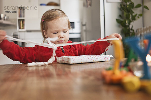 Geschenk  sitzend  klein  auspacken  Mädchen  Tisch