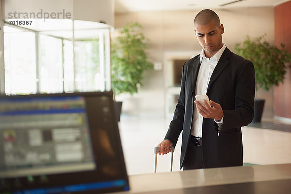 Geschäftsmann mit Handy in der Lobby