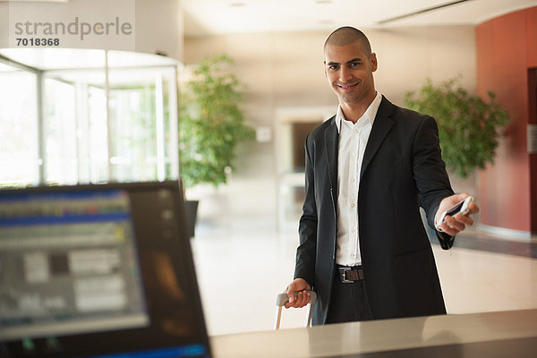 Geschäftsmann mit Handy in der Lobby