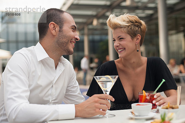 Lächelndes Paar bei einem Drink im Freien