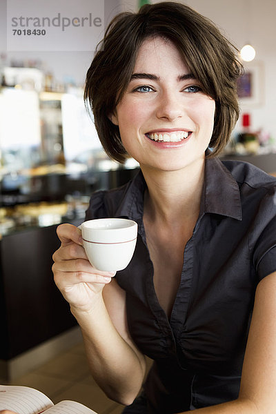 Lächelnde Frau beim Kaffee im Café