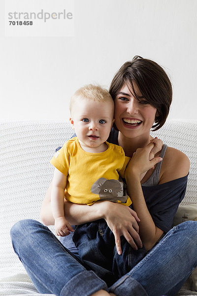 Mutter und Baby sitzen auf dem Bett