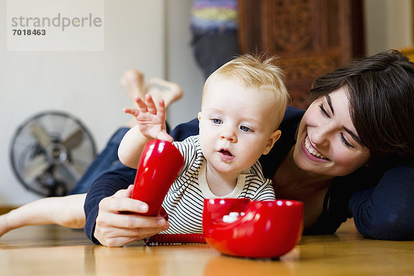 Mutter und Baby spielen auf dem Boden