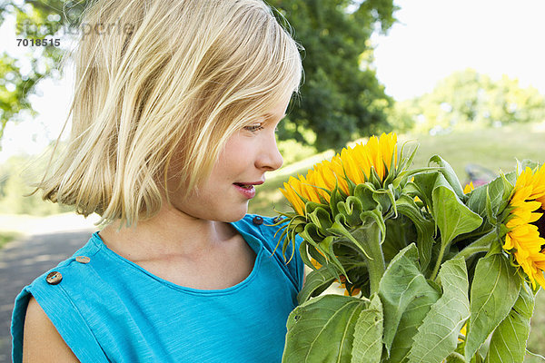 Lächelndes Mädchen mit Sonnenblumen