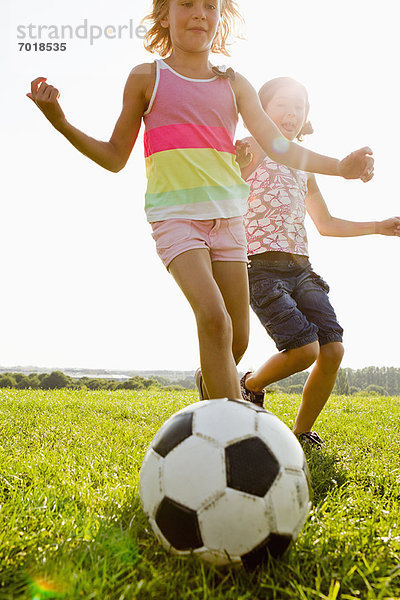 Mädchen spielen Fußball im Feld