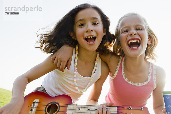 Mädchen singen gemeinsam im Freien