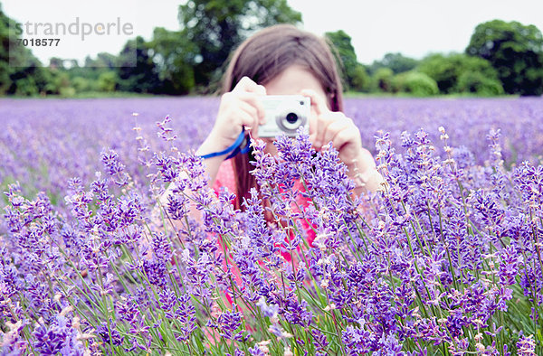 Mädchen beim Fotografieren von Blumen