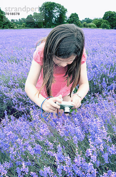 Mädchen beim Fotografieren von Blumen