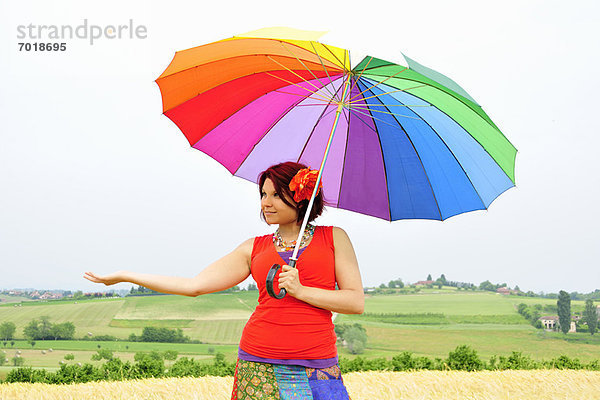 Frau mit farbenfrohem Regenschirm