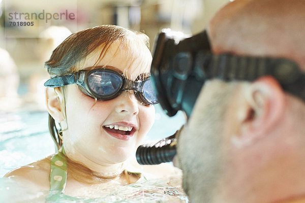 Vater und Tochter schwimmen im Pool