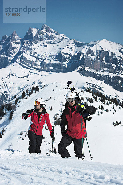 Skifahrer klettern auf verschneite Berghänge