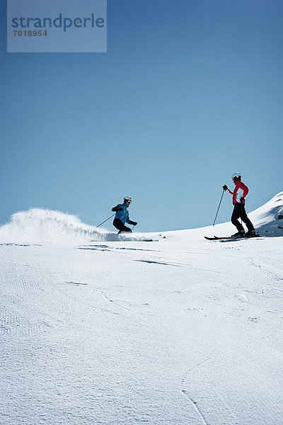 Skifahrer fahren auf verschneiter Piste