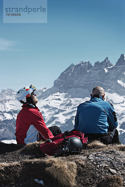 Skifahrer  die sich auf einer felsigen Bergspitze ausruhen