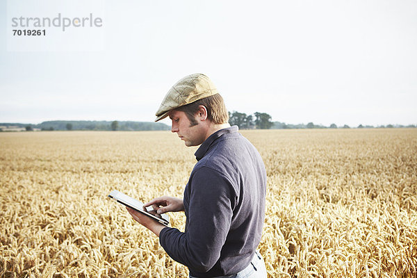 Landwirt mit Tablet-Computer im Feld