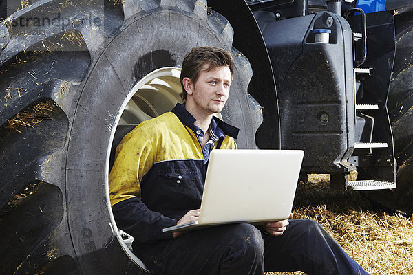 Landwirt mit Laptop im Feld