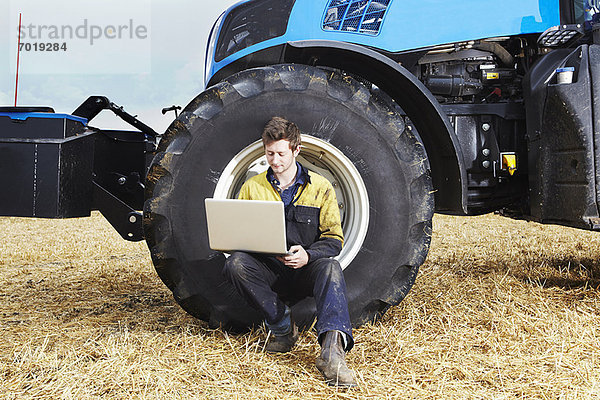 Landwirt mit Laptop im Feld