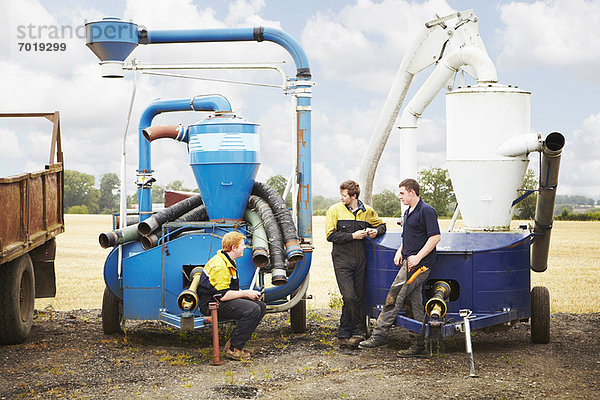 Landwirte im Gespräch mit Maschinen im Feld