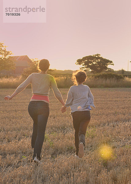 Mutter und Tochter laufen auf dem Feld