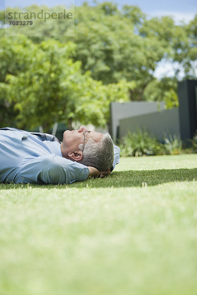 Erwachsener Geschäftsmann schläft auf Gras