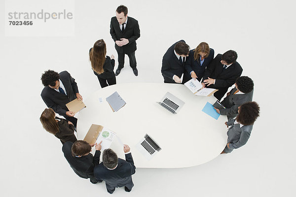 Geschäftspartner  die in Gruppen um den Tisch herum zusammenarbeiten