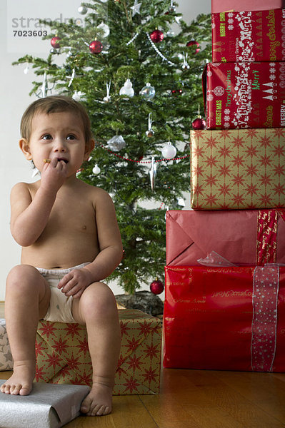 Mädchen sitzt auf Weihnachtsgeschenk  isst Snack