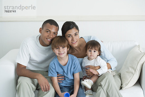 Familie sitzt zusammen auf dem Sofa  Porträt