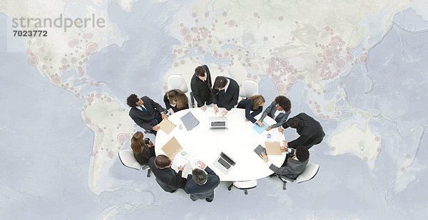 Treffen von Geschäftsführern auf der überlagerten Weltkarte