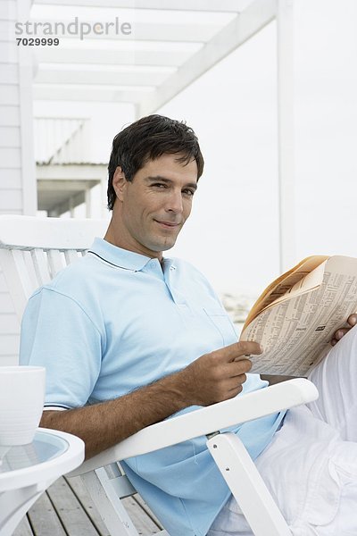 Mann  Stuhl  Mittelpunkt  Erwachsener  Zeitung  vorlesen