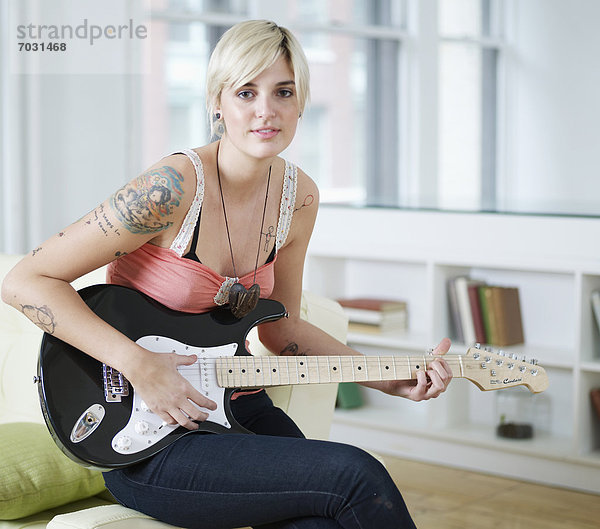 Junge Frau spielt E-Gitarre