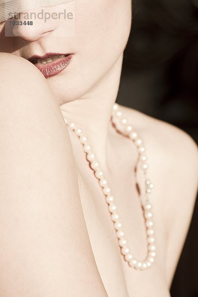 Junge Frau trägt eine Perlenkette