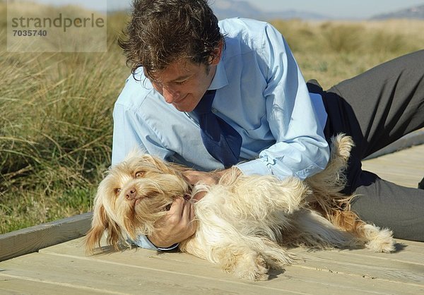 Außenaufnahme Mann Hund streicheln freie Natur