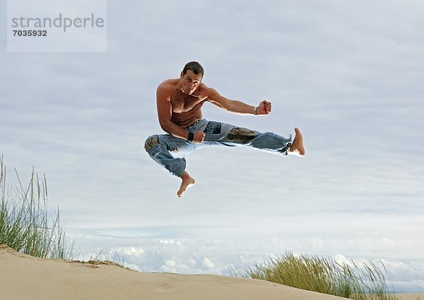 Mann nehmen Strand Kunst Kampfsportler Pose