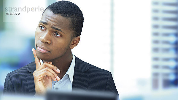 Geschäftsmann  jung  afroamerikanisch  amerikanisch  seriös  nachdenklich  konzentriert  im Büro