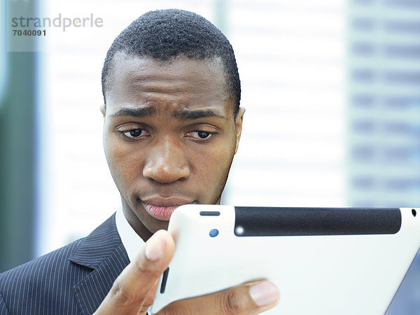 Geschäftsmann  jung  afroamerikanisch  amerikanisch  seriös  konzentriert  mit iPad