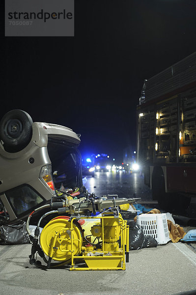 Hydraulisches Rettungsgerät der Feuerwehr bei einem Verkehrsunfall auf der A 8. Im Hintergrund ein auf dem Dach liegendes Auto (Microcar) / Denkendorf   Baden-Württemberg   Deutschland   Europa